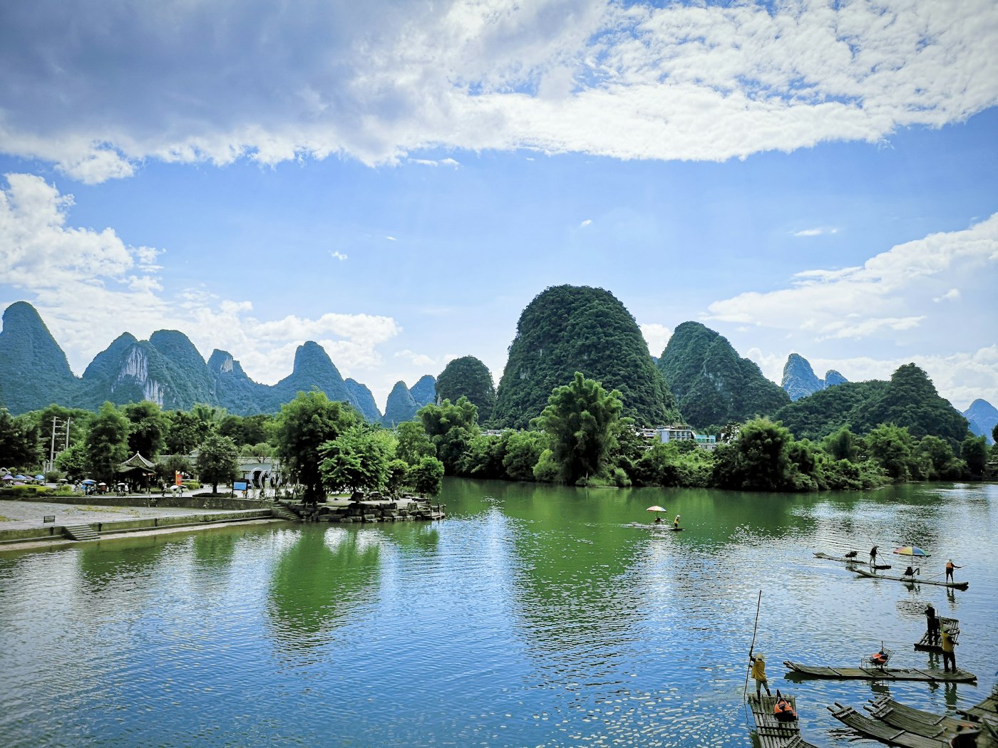 Bamboo rafts on a green river surrounded by karst peaks near Yangshuo, Guilin